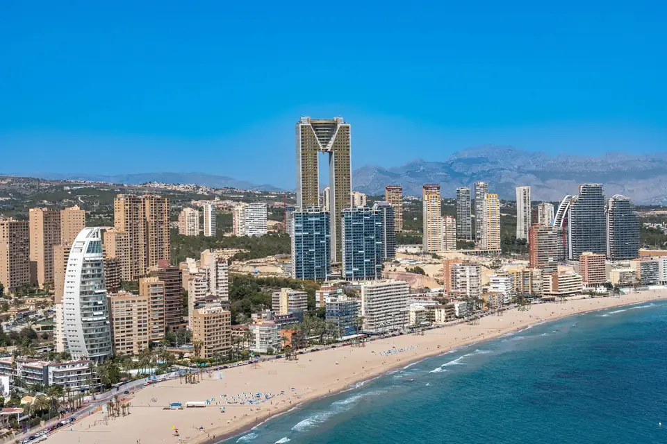 Vista aérea de Benidorm, con la playa, los rascacielos y las sierras de la Marina Baixa
